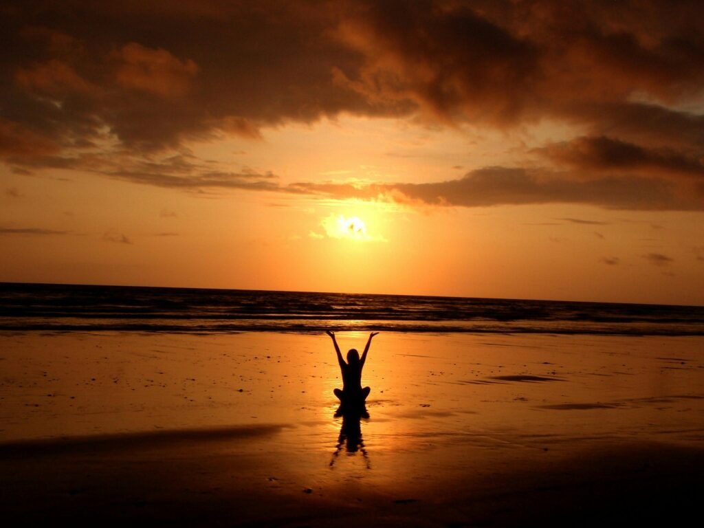 woman happy after meditating on beach